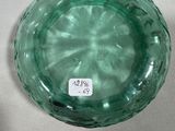 a green glass bowl sitting on a white table