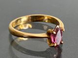 une bague en or sertie d'une pierre rose