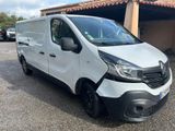 La camionnette blanche est garée devant un garage.