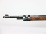 an old rifle with a wooden handle on a white surface