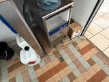 a person standing under a kitchen counter with a microwave