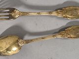 two spoons and a fork sitting on a table