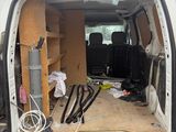 the back of a van with the door open and a bunch of tools in the back