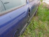 a blue car that has a hole in the side of it