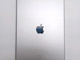 an apple ipad sitting on top of a white table with a blue apple logo on the back of it