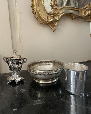 un bol en argent et une coupe en argent posés sur une table
