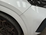 a close up of a white car parked in a parking lot