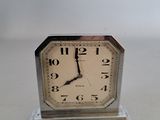 une petite horloge posée sur une table