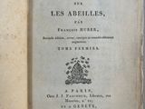 un livre ouvert posé sur une table, sur fond bleu