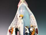 figurine représentant une statue de femme coiffée d'une couronne, entourée d'autres figurines