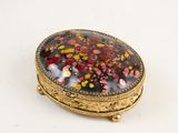 an image of a gold and red broochle on a white surface