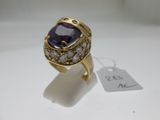 un gros plan d'une bague en or sertie d'une pierre violette