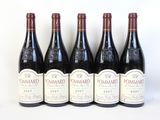 six bouteilles de vin sont alignées sur une surface blanche