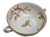 a white bowl with a gold decoration on it
