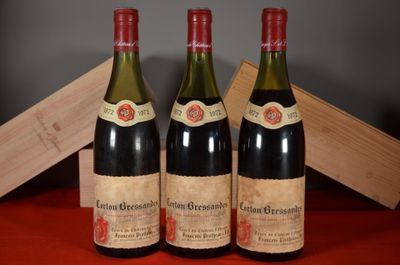 three bottles of wine are sitting on a table next to a wooden box