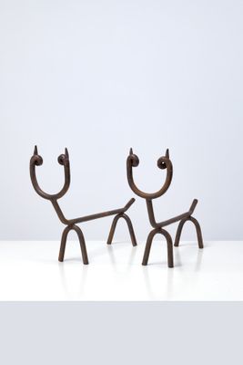 deux sculptures métalliques représentant un homme et un chien sur une surface blanche
