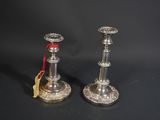 une paire de bougeoirs en argent ornés d'un ruban rouge sur fond noir