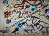 many different necklaces and bracelets laid out on a table