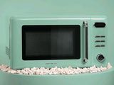 un micro-ondes vert posé sur une table