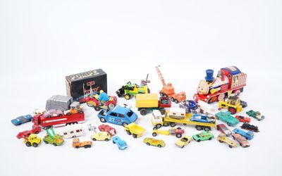 un tas de petites voitures et de camions jouets posés sur une surface blanche