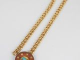une photo d'un collier en or orné d'une pierre turquoise