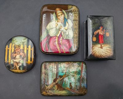 trois petites boîtes en fer-blanc ornées de peintures, posées sur une table