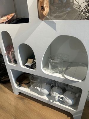 une étagère blanche sur laquelle sont posées des tasses et des verres