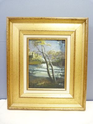 l'image d'un tableau représentant une rivière, dans un cadre doré, posé sur une surface blanche