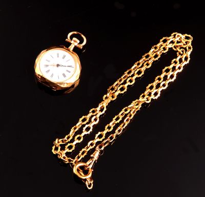 gold plated pocket watch and chain on a black background