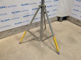an image of a tripod stands in front of a wall with a sign