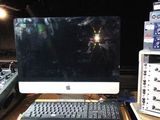 un écran d'ordinateur et un clavier posés sur un bureau dans un studio d'enregistrement