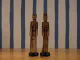 two wooden figurines that are standing on a table