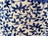 a blue and white vase with a blue flower on it