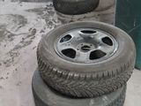 four tires sitting on the ground next to a trash can