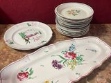 de nombreuses assiettes et bols sur la table, avec un mur rouge en arrière-plan