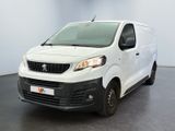La petite camionnette blanche est garée dans une grande pièce.