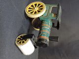 a toy train with wheels and a can of soda on the ground