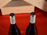 two bottles of wine sitting next to each other on a table