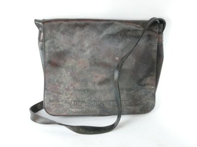an image of a brown leather bag with a strap on a white background