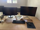 un bureau sur lequel sont posés deux écrans d'ordinateur et un clavier