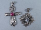 deux pendentifs en forme de croix en argent, ornés d'une pierre rose au centre