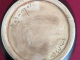 a wooden bowl with writing on it on a red surface