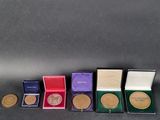 four different types of medals are lined up on a table