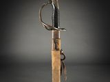 a close up of a sword with a wooden handle on a black background