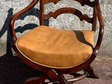 a wooden chair with a tan seat and a brown cushion