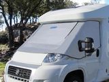 un petit camping-car blanc garé dans l'herbe