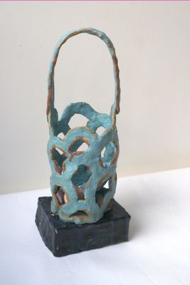 une petite sculpture représentant un panier posé sur une table