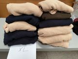 Plusieurs paires de pulls sont empilées sur une table dans une pièce