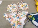 two bikinis and a bathing suit on a couch