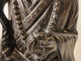 a silver statue of a man holding a stick